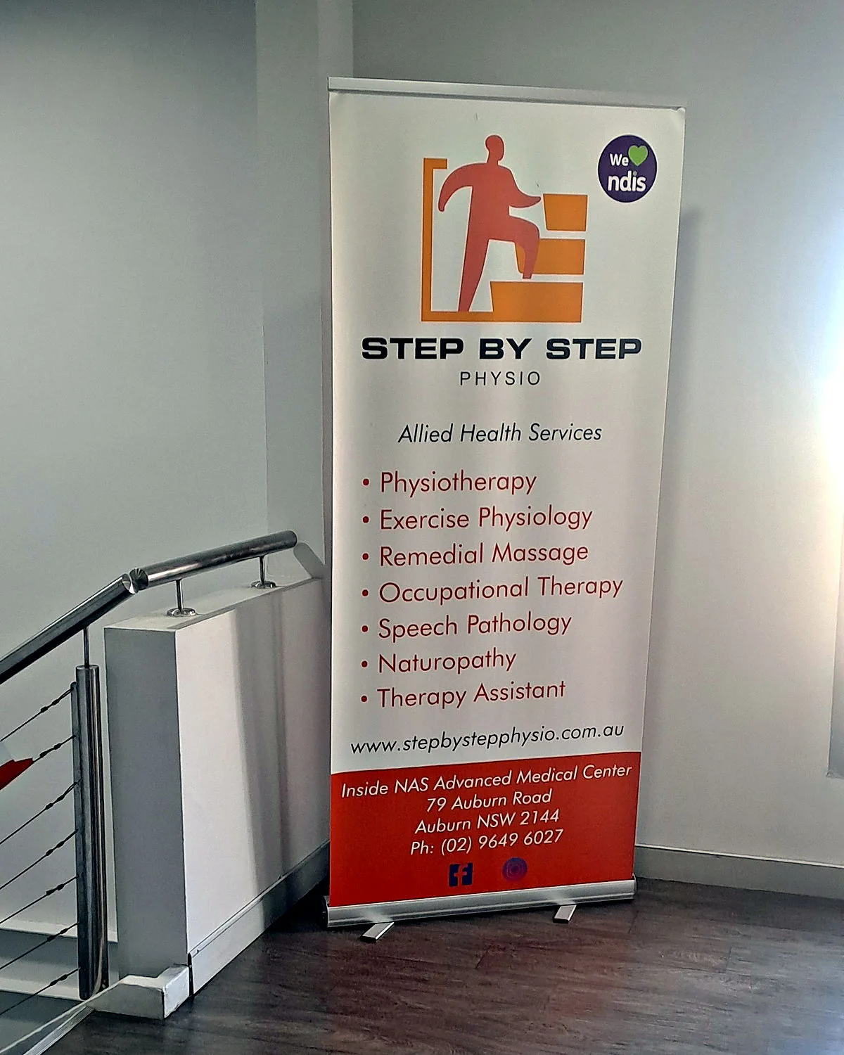 Step By Step Physio banner at the top of the stairs in our Auburn clinic