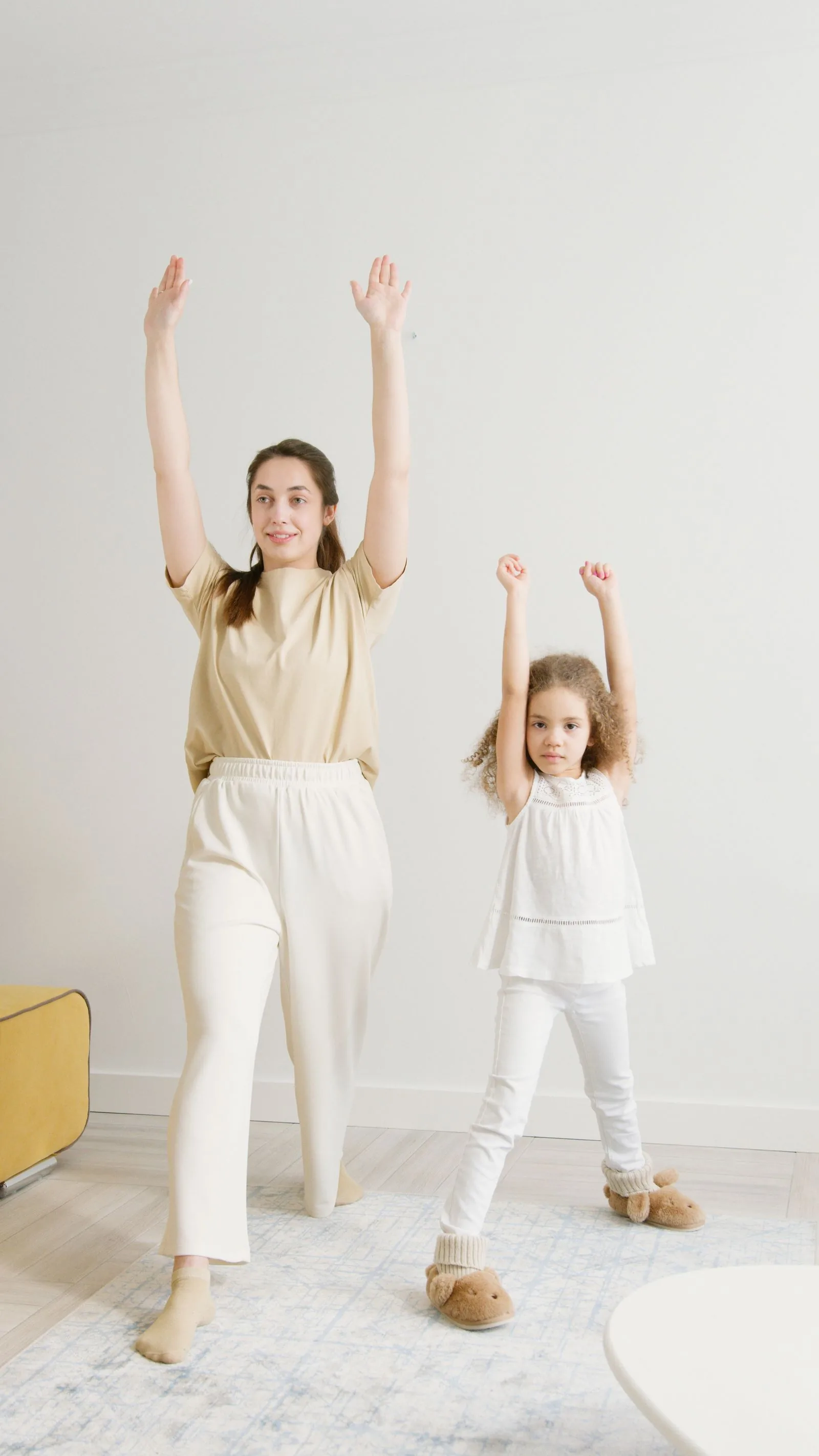 A parent and child stretching together during an exercise physiology session